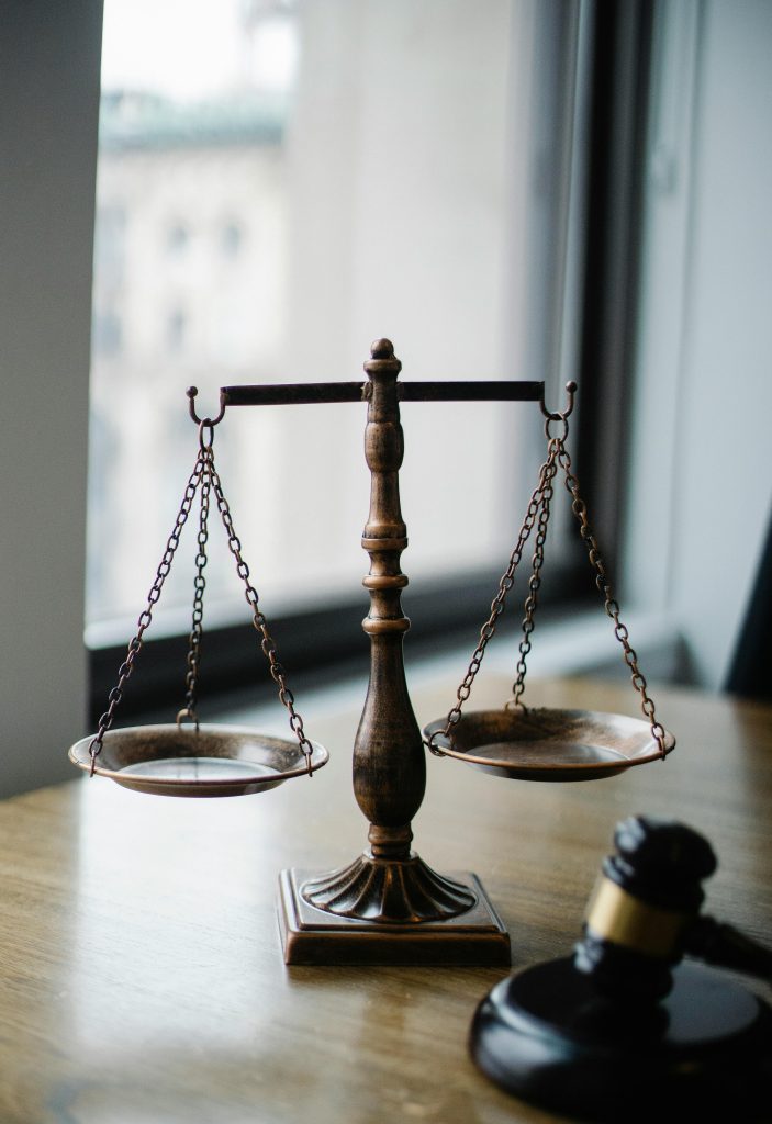 pexels-photo-5669602-5669602 Decorative judgement scale and gavel placed on desk in light lawyer office against window